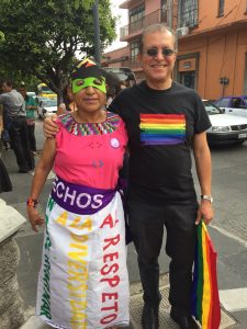 two people pose together wearing rainbow gear